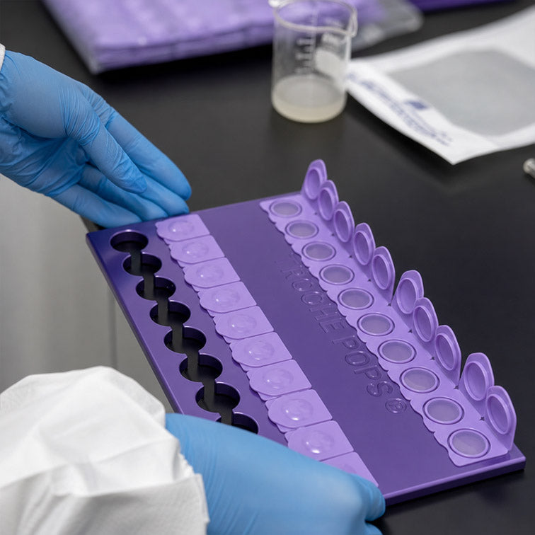 Gloved hands working with a troche mold tray in the Lititz Apothecary compounding lab