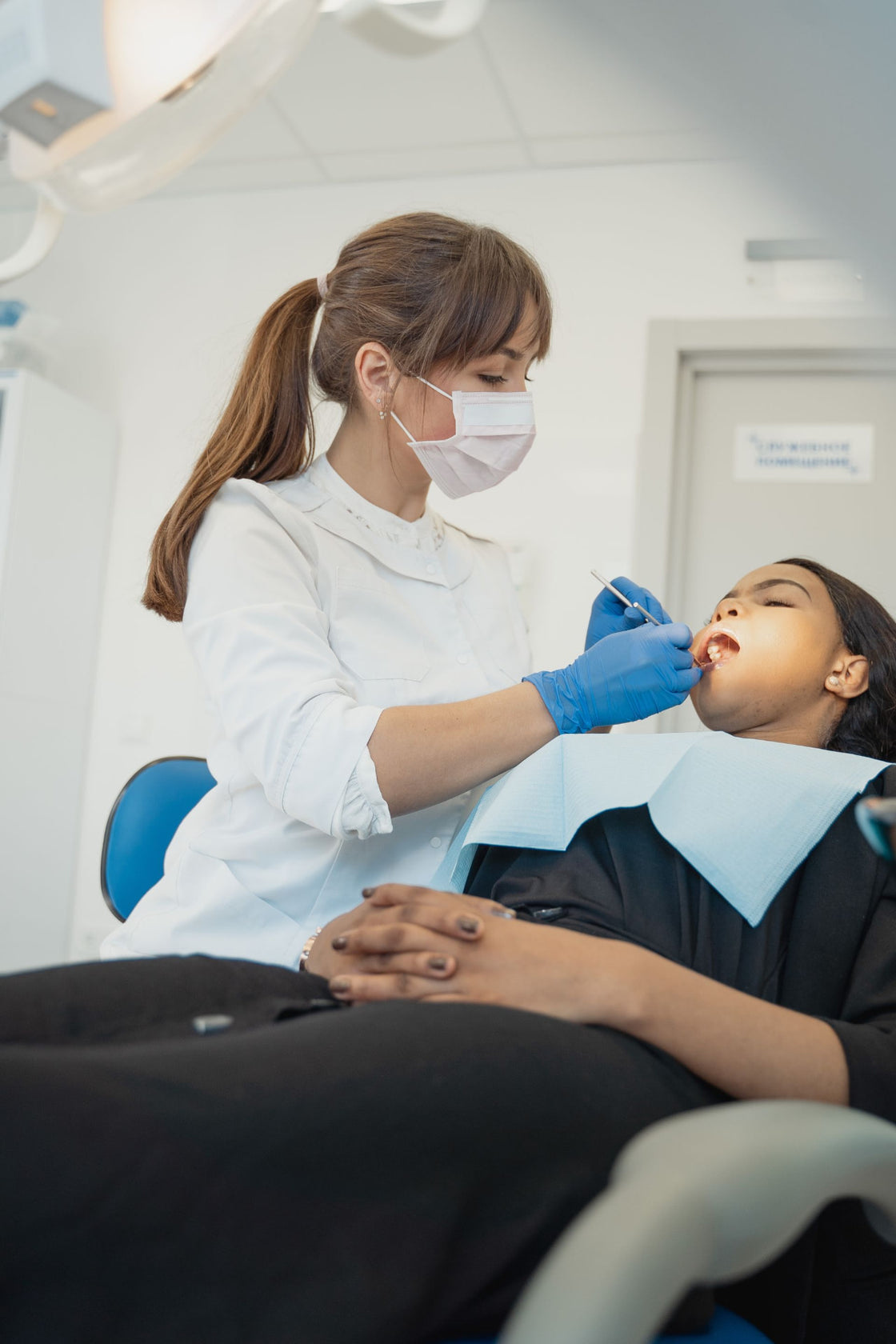 Dental hygienist examining a patient in a dental chair