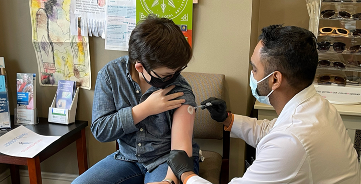 Pharmacist giving a vaccination in the upper arm of a young patient