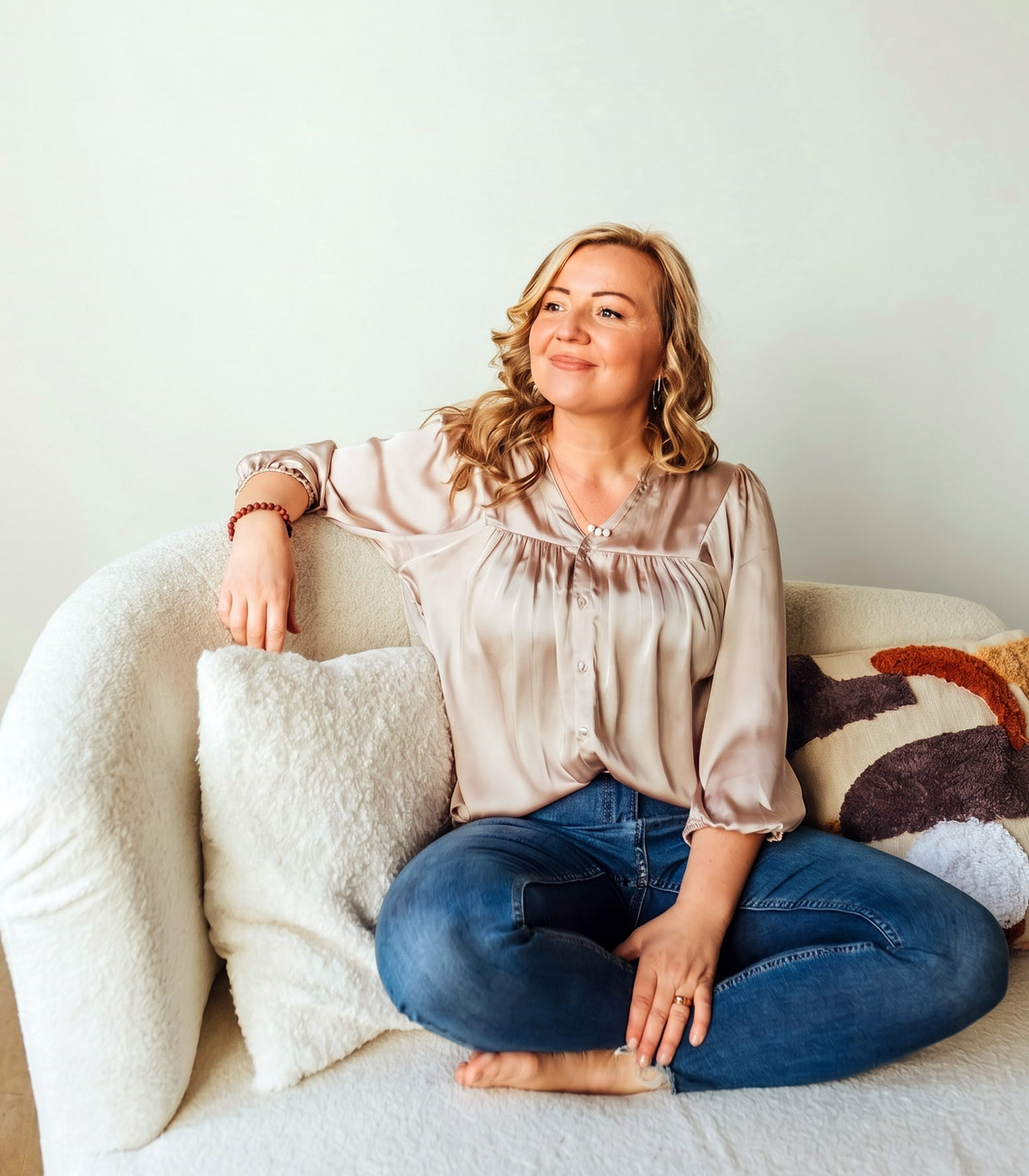 Smiling woman relaxing on a white sofa at home