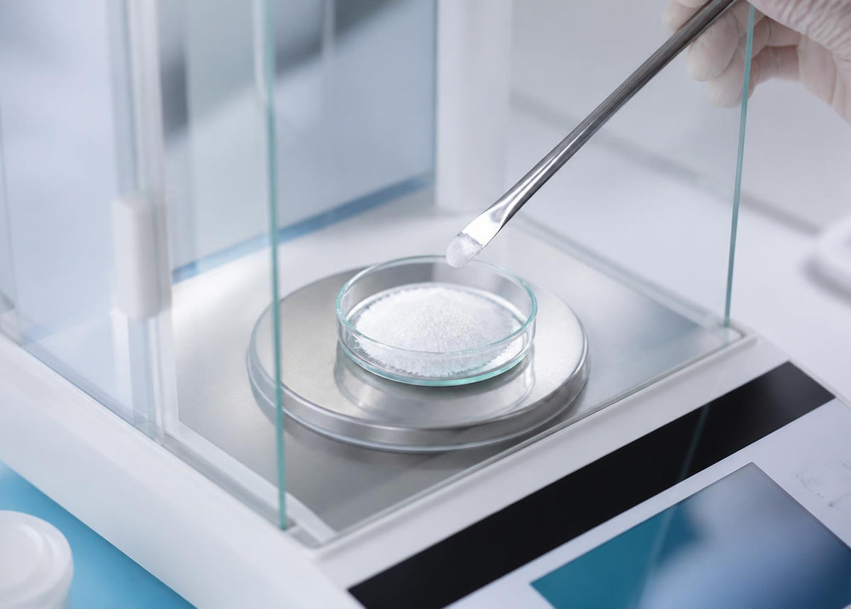 Powdered ingredient being weighed on an analytical balance